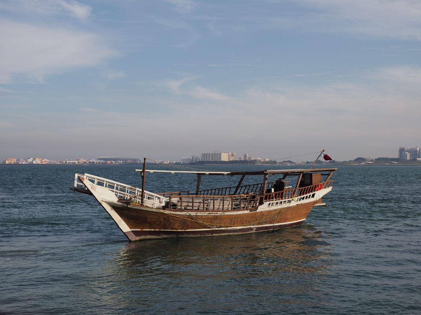Traditional wooden dhows moored together at a Gulf harbour